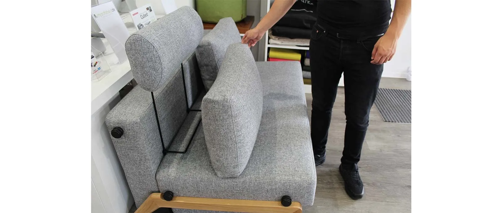 Der Bügel der Kopfstütze FLIP wird einfach zwischen Sofapolster und Rückenkissen gesteckt - hier beim CUBED 140 Schlafsofa