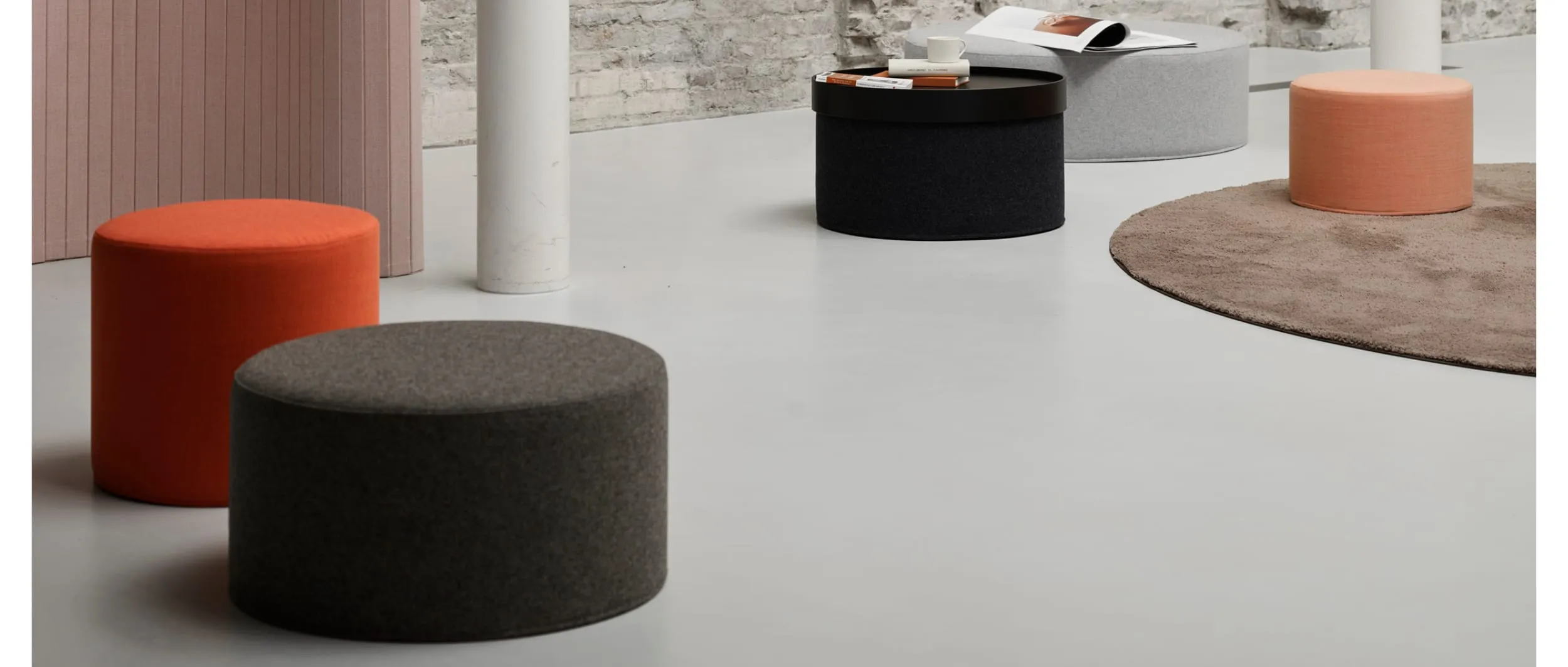 Den Sitzhocker DRUM von Softline können Sie in vielen verschiedenen Größen und Stoffen bestellen, um Ihre Sitzgruppe zu gestalten