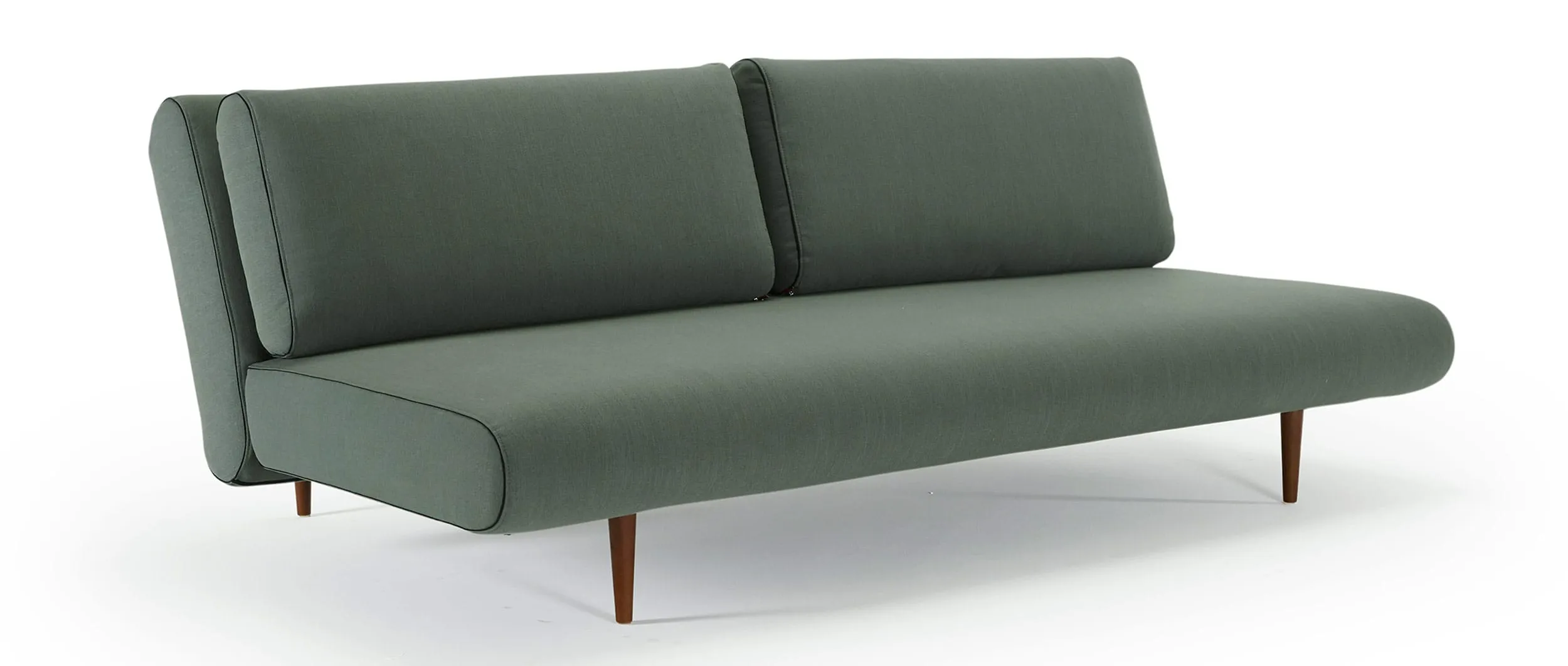 Das UNFURL LOUNGER Schlafsofa von Innovation im Stoff Elegance Green (518) und mit dunkelbraun gebeizten Styletto Holzfüßen