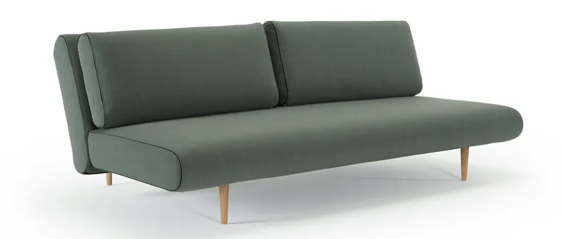 Das UNFURL LOUNGER Schlafsofa im grünen Standardstoff und mit hellen Styletto Holzfüßen (Sonderanfertigung)