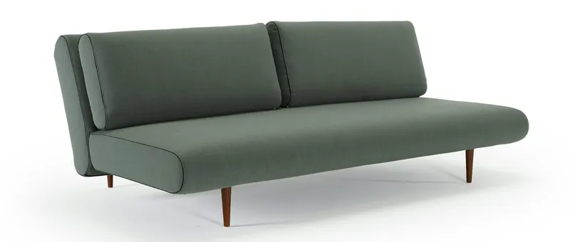 Das UNFURL LOUNGER Schlafsofa von Innovation im Stoff Elegance Green (518) und mit dunkelbraun gebeizten Styletto Holzfüßen