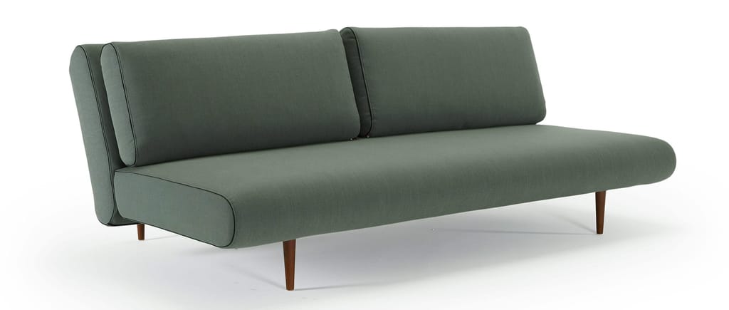 Das UNFURL LOUNGER Schlafsofa von Innovation im Stoff Elegance Green (518) und mit dunkelbraun gebeizten Styletto Holzfüßen