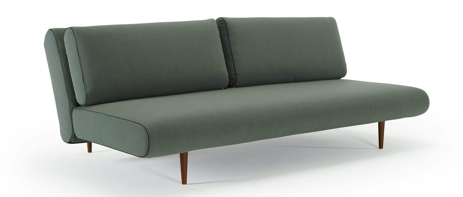 Das UNFURL LOUNGER Schlafsofa von Innovation im Stoff Elegance Green (518) und mit dunkelbraun gebeizten Styletto Holzfüßen