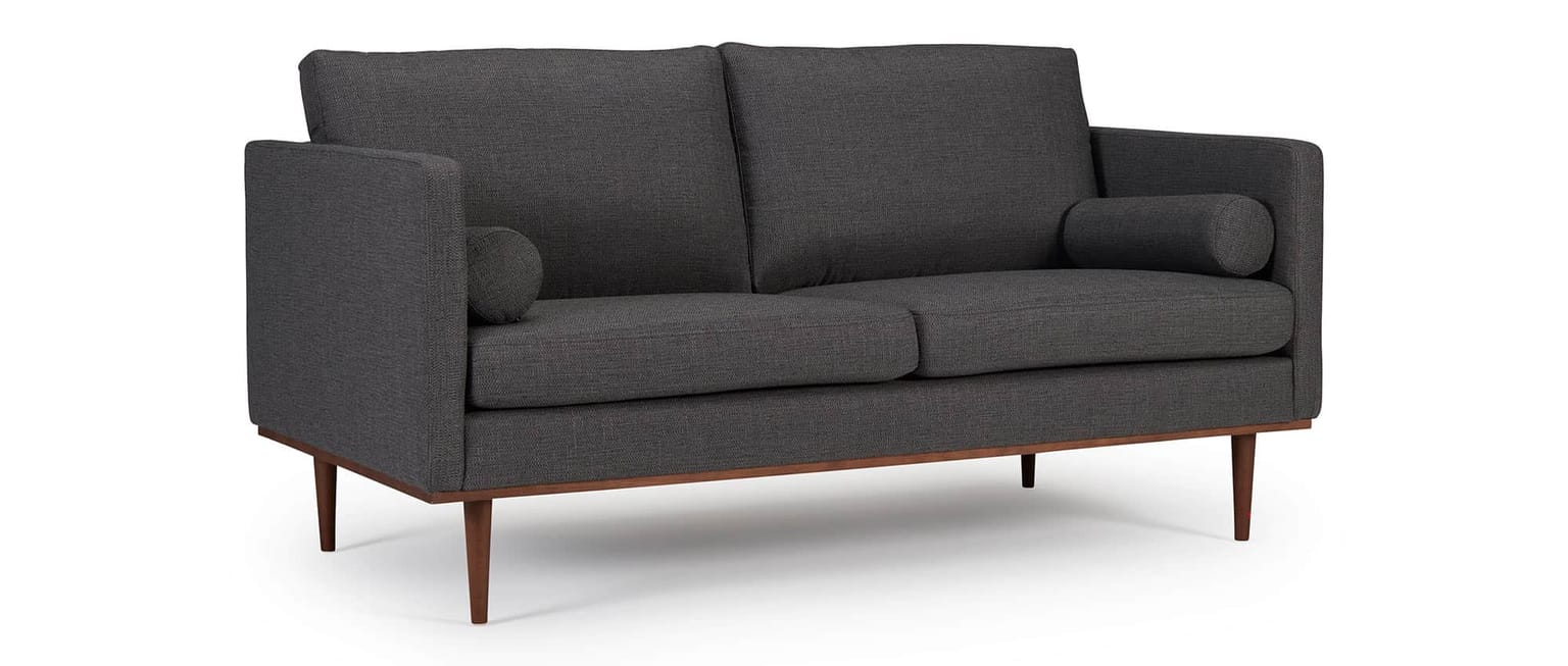 Das OSLO Designer Sofa mit Polsterarmlehnen, runden Seitenkissen und dunklen Holzfüßen aus Eiche